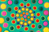 Colourful dot mandala detail, yellow green blue pink orange purple on green background