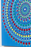 Colourful dot mandala detail, blue background, red yellow green purple white