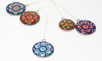 A collection of colourful dotted resin pendants with sterling silver chains