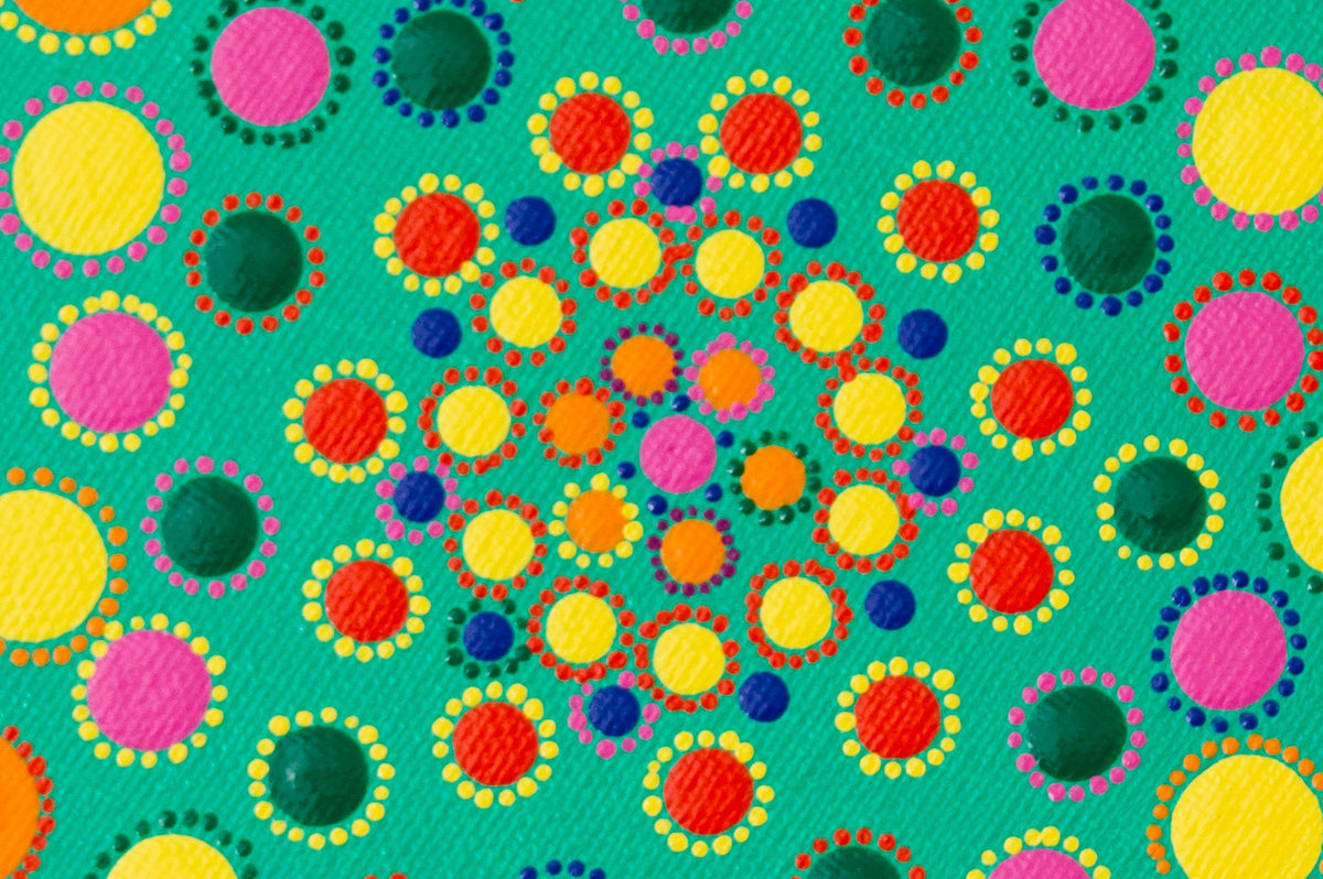 Colourful dot mandala detail, yellow green blue pink orange purple on green background