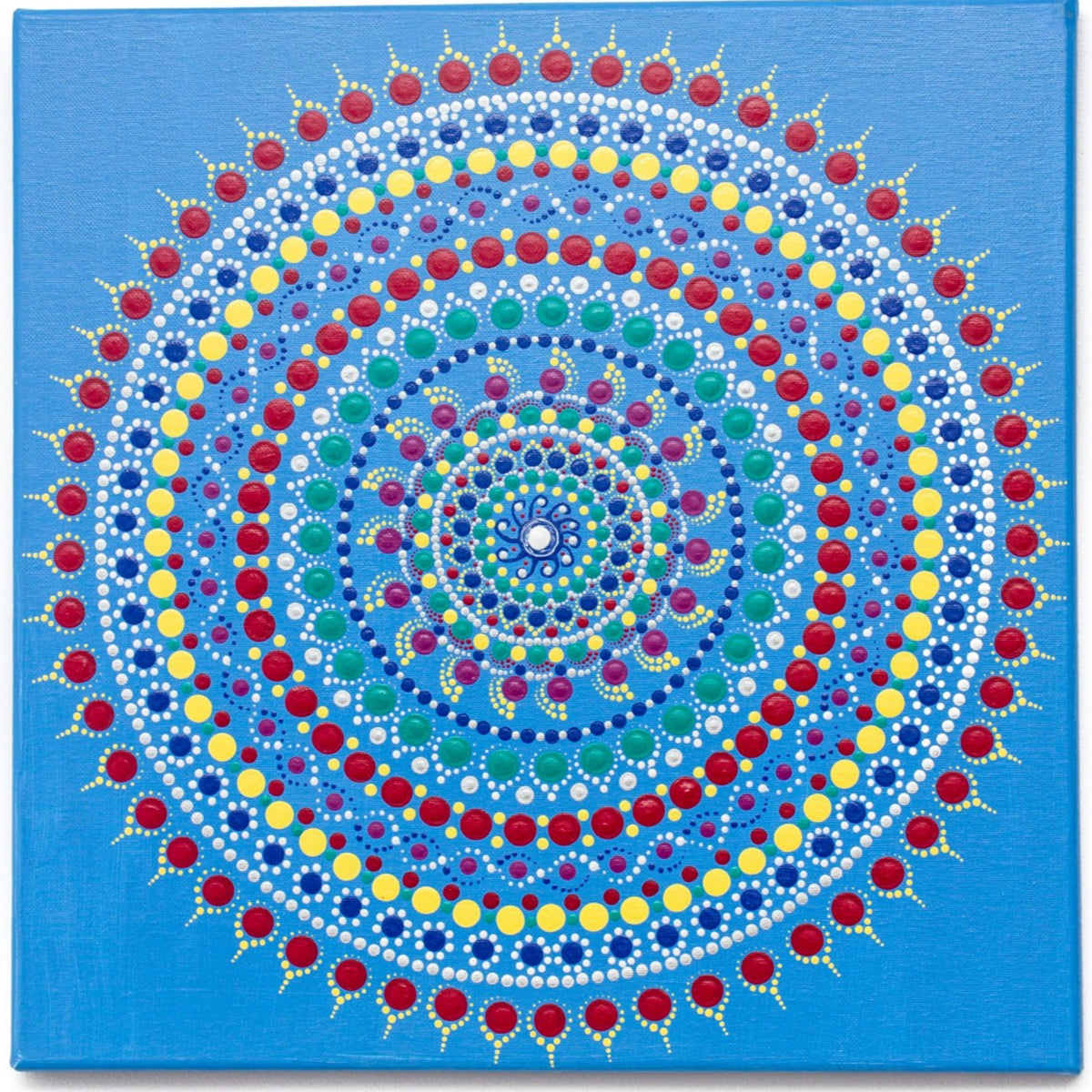 Colourful dot mandala on blue background, red yellow green purple white