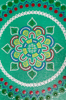 Dot mandala detail, red green yellow blue on green background