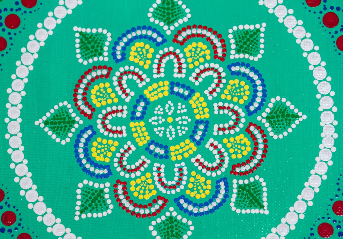 Dot mandala detail, red green yellow blue on green background