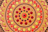 Dot Mandala detail, gold red yellow brown on peach colour background