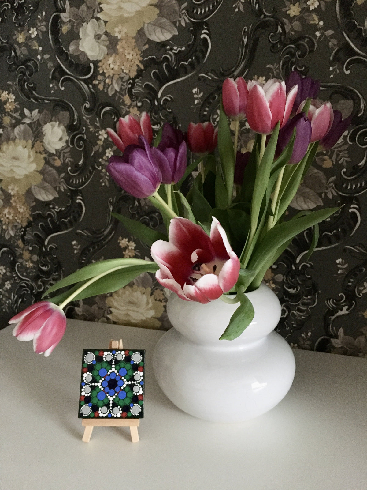 Small dot mandala with easel by vase green blue white red silver